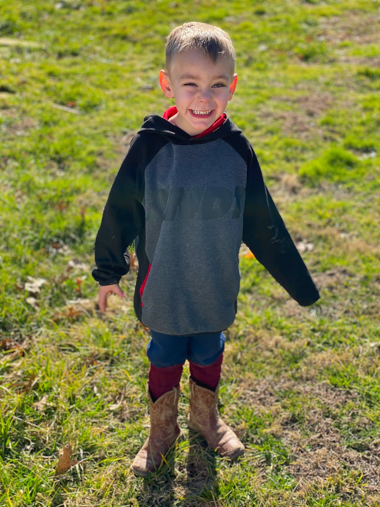 Brenton is registered to the contest to win money with this photo: baby_toddler_clothing, child, face, grass, grass_family, grassland, happy, head, joy, landscape, meadow, natural_environment, natural_landscape, pattern, people_in_nature, person, plant, prairie, sleeve, smile