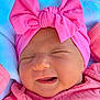 baby, newborn, pink_bow, headband, pink_clothing, smiling, face, closed_eyes, blanket, outdoor, greenery, infant, cute, portrait, soft_texture, child, headwear, happy, resting, baby_girl