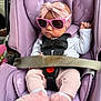 baby, child, car_seat, sunglasses, headband, pink, purple, infant, clothing, footwear, straps, safety_belt, cute, fur, indoor, person, seat, fashion, accessory, expression