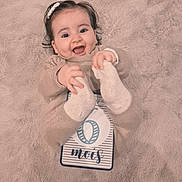 Alba a rejoint le concours — aidez-le/la à gagner de superbes lots ! baby, infant, smile, happy, milestone_card, blanket, soft_texture, cute, clothing, hands, feet, headband, person, portrait, lying_down, cozy, warm, child, celebration, newborn