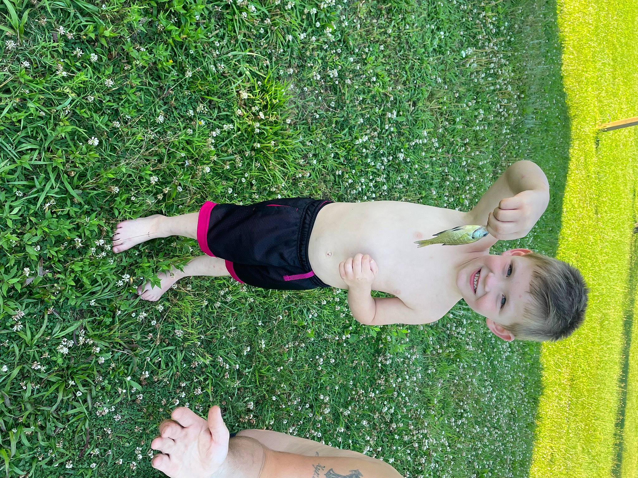 Julian is registered to the contest to win money with this photo: elbow, flooring, foot, fun, grass, grassland, groundcover, happy, human_body, human_leg, joy, knee, lawn, leisure, pattern, people_in_nature, person, plant, shrub, thigh