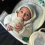 baby, bottle, hoodie, knitwear, infant, pacifier, seat, soft_toy, white, cream, cute, child, hand, face, indoors, portrait, feeding, newborn, cozy, comfortable