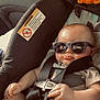 baby, car_seat, sunglasses, child, toy, lion_toy, seatbelt, car_interior, infant, cool, sitting, child_safety, straps, clothing, hand, face, head, cute, sunlight, relaxing