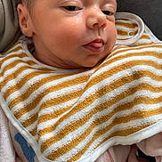 Amaya a rejoint le concours — aidez-le/la à gagner de superbes lots ! baby, infant, newborn, face, cheek, bib, striped_bib, onesie, sleepy, tongue_out, close_up, portrait, skin, hair, eyelids, blanket, fabric, side_profile, indoors, snuggled