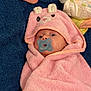 baby, infant, pacifier, hooded_towel, pink_towel, blanket, diaper, socks, cartoon_hood, eyes, wrapped, newborn, bath_time, nursery_item, soft_texture, towel, cute, lying_down, blue_background, baby_care_item