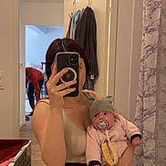 Amaya a rejoint le concours — aidez-le/la à gagner de superbes lots ! baby, infant, pacifier, hat, adult, parent, mirror, selfie, smartphone, bathroom, shower_curtain, towel, doorway, person_bending, clothing, sink, mirror_reflection, basket, floor, portrait