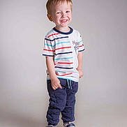 Malo a rejoint le concours — aidez-le/la à gagner de superbes lots ! child, boy, smiling, standing, striped_shirt, pants, shoes, indoor, studio, portrait, happy, casual_clothing, footwear, cute, young, light_background, full_length, posing, small_child, playful