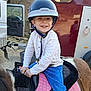 Malo a rejoint le concours — aidez-le/la à gagner de superbes lots ! child, helmet, pony, saddle, pink_saddle, blue_pants, white_shirt, smiling, outdoor, animal, horse, vehicle, trailer, reins, happy, boy, riding, daylight, nature, fun