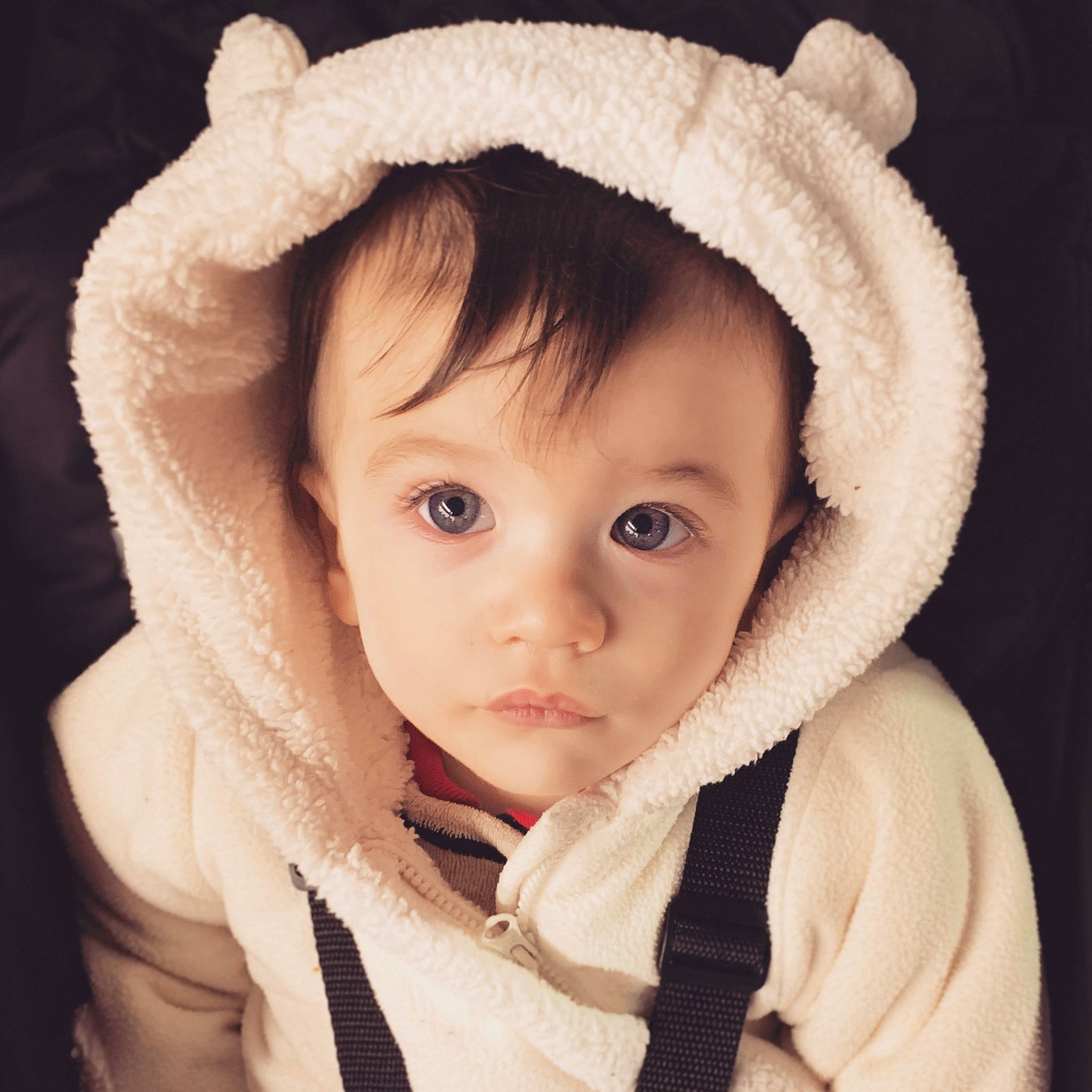 Quentin is registered to the contest to win money with this photo: beige, bonnet, cheek, child, child_model, ear, eye, face, fur, fur_clothing, head, headgear, hood, knit_cap, lip, organ, outerwear, person, skin, toddler