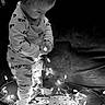 black_and_white, child, christmas_lights, couch, cozy, curious, cute, decor, face, holiday, home, illumination, indoor, lights, pajamas, playing, snowflake, string_lights, toddler, young_child