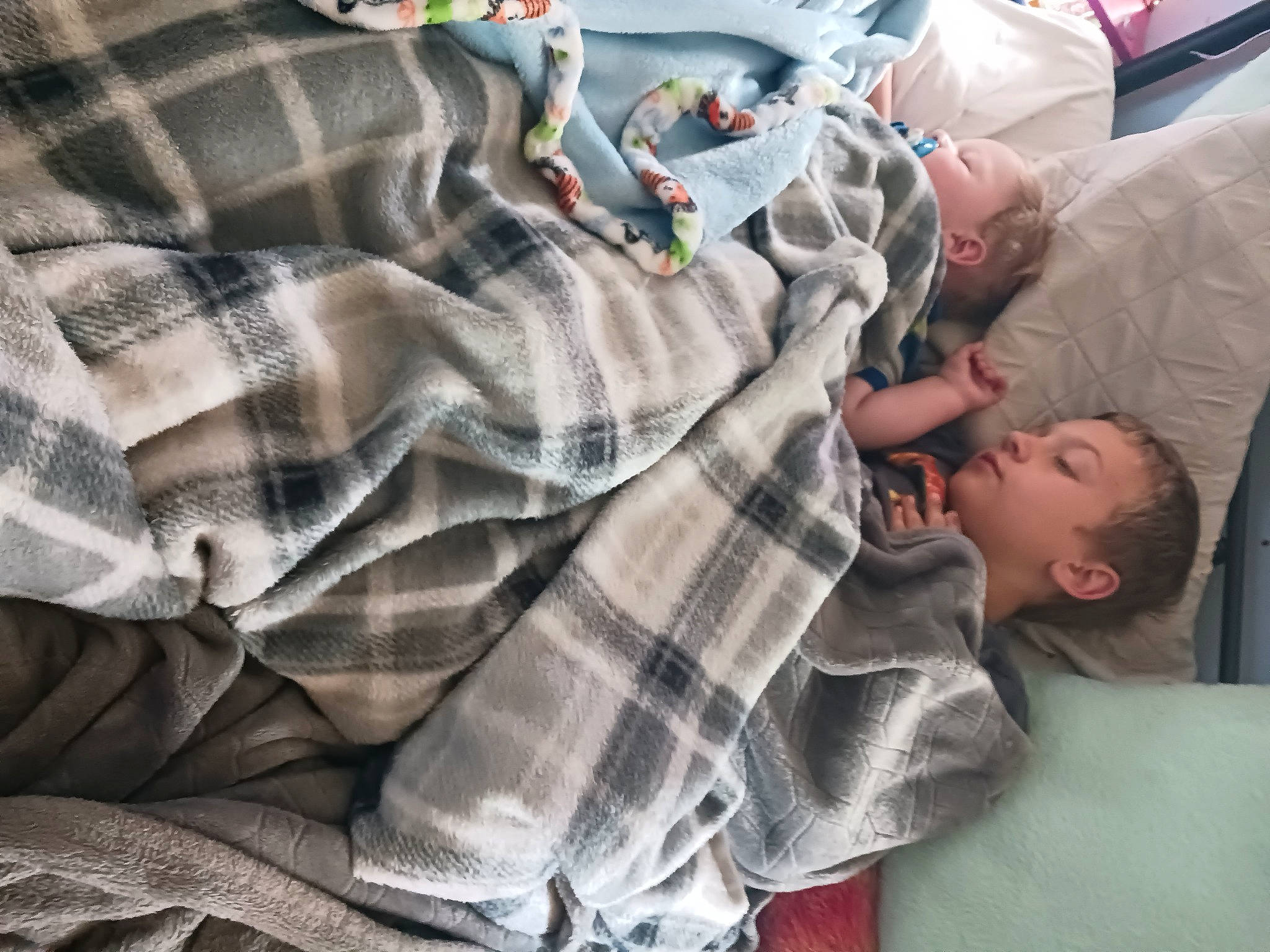 Colt is registered to the contest to win money with this photo: baby, baby_products, baby_toddler_clothing, bedding, bedtime, child, comfort, human_leg, linens, mammal, nap, pattern, person, plaid, room, sitting, sleeve, t_shirt, tartan, textile