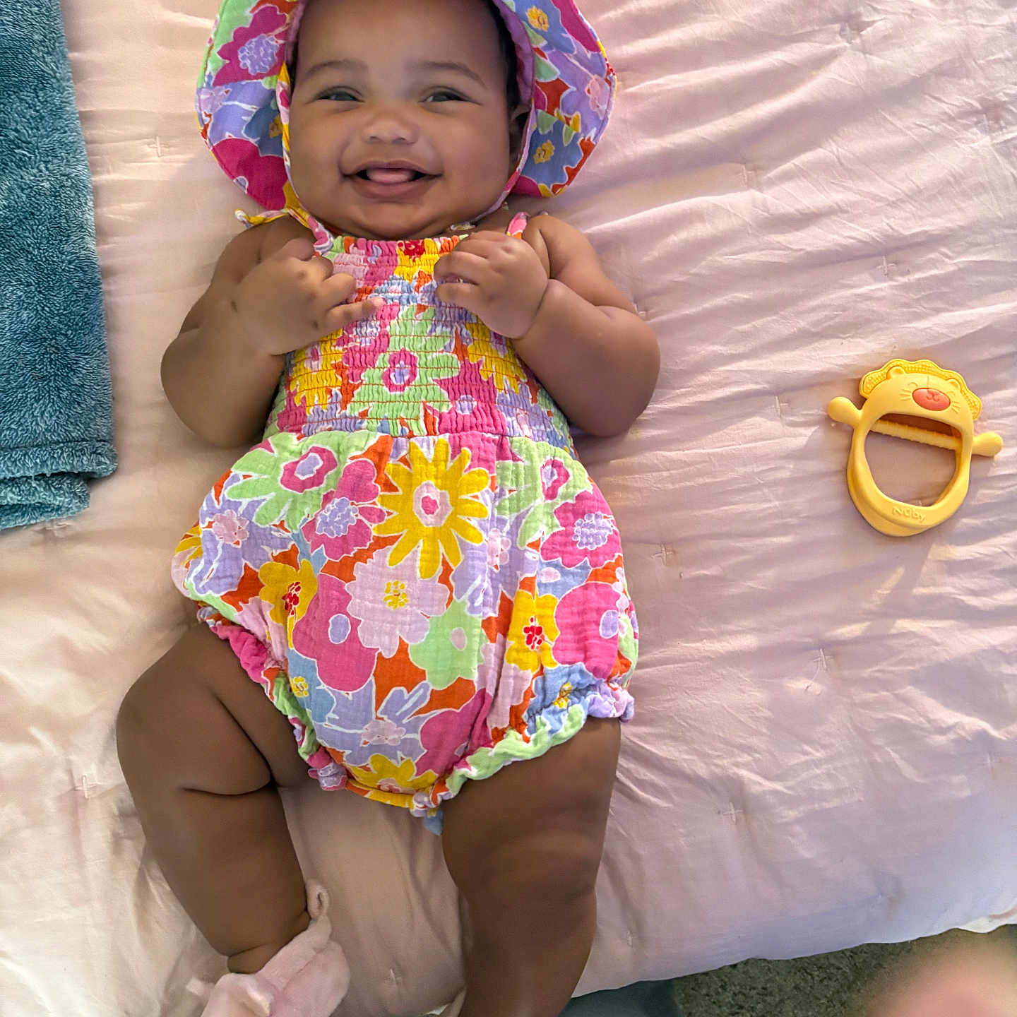 Kaveah joined the competition — help win amazing prizes! baby, infant, child, smiling, happy, portrait, floral_outfit, sun_hat, colorful_clothing, lying_down, bed, blanket, pink, toy, mirror, indoor, home, bare_legs, socks, photography