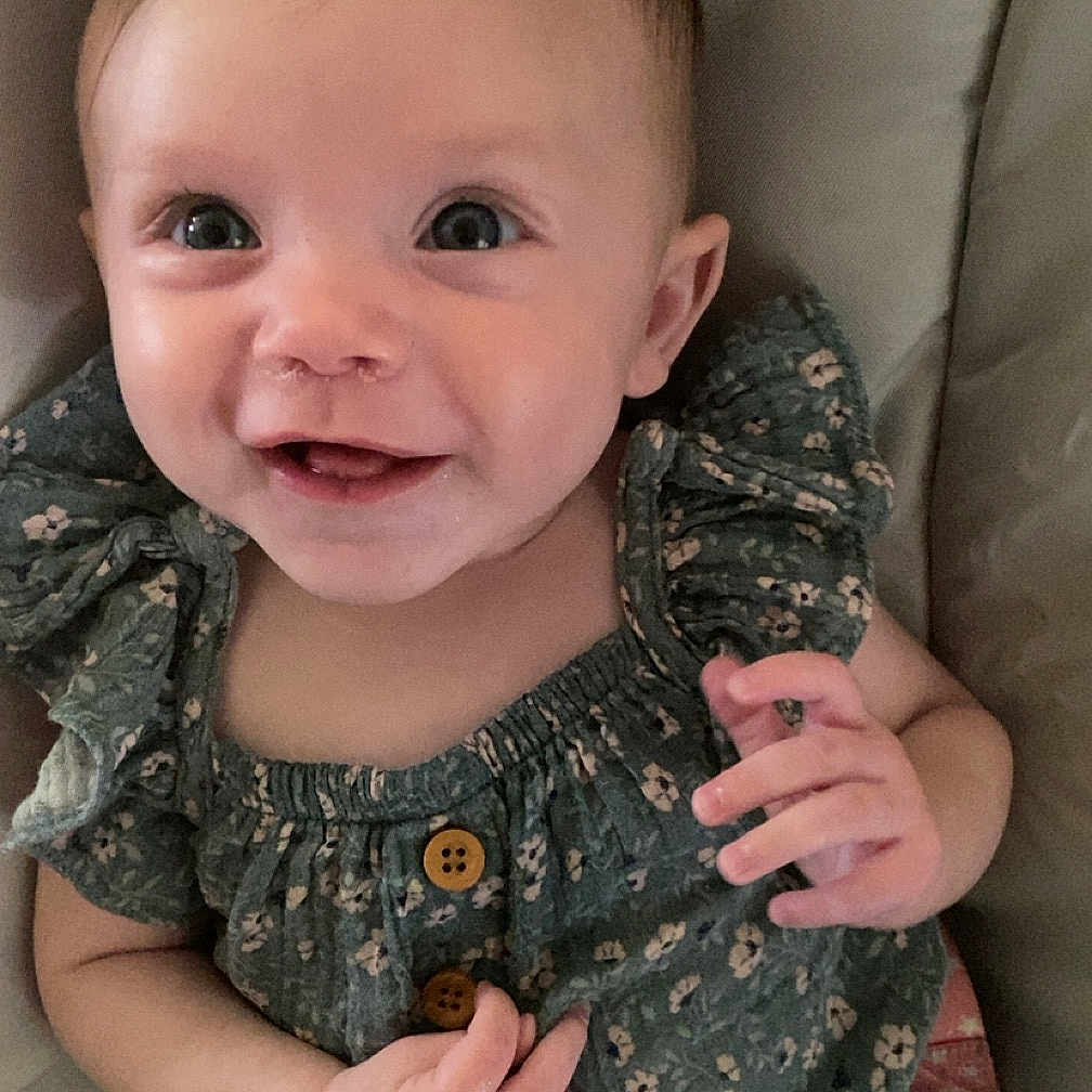 Isabelle joined the competition — help win amazing prizes! baby, bodypart, clothing, couch, cushion, dress, face, finger, furniture, hand, happy, head, homedecor, laughing, pants, person, photography, portrait, sitting, smile