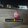 child, girl, night, parking_lot, gas_station, building, car, jacket, bottle, outdoor, streetlight, pavement, person, clothing, smiling, holding, urban, sidewalk, dark, portrait