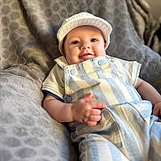 Giulio participe au concours pour gagner de l'argent avec cette photo : baby, infant, smile, face, cap, clothing, overalls, blanket, fabric, pattern, texture, person, cute, child, soft, resting, indoor, comfort, happy, portrait