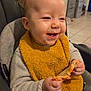 baby, infant, highchair, bib, food, eating, messy, smile, happy, hands, meal, indoor, kitchen, tile_floor, clothing, seat, closeup, face, teeth, cheese