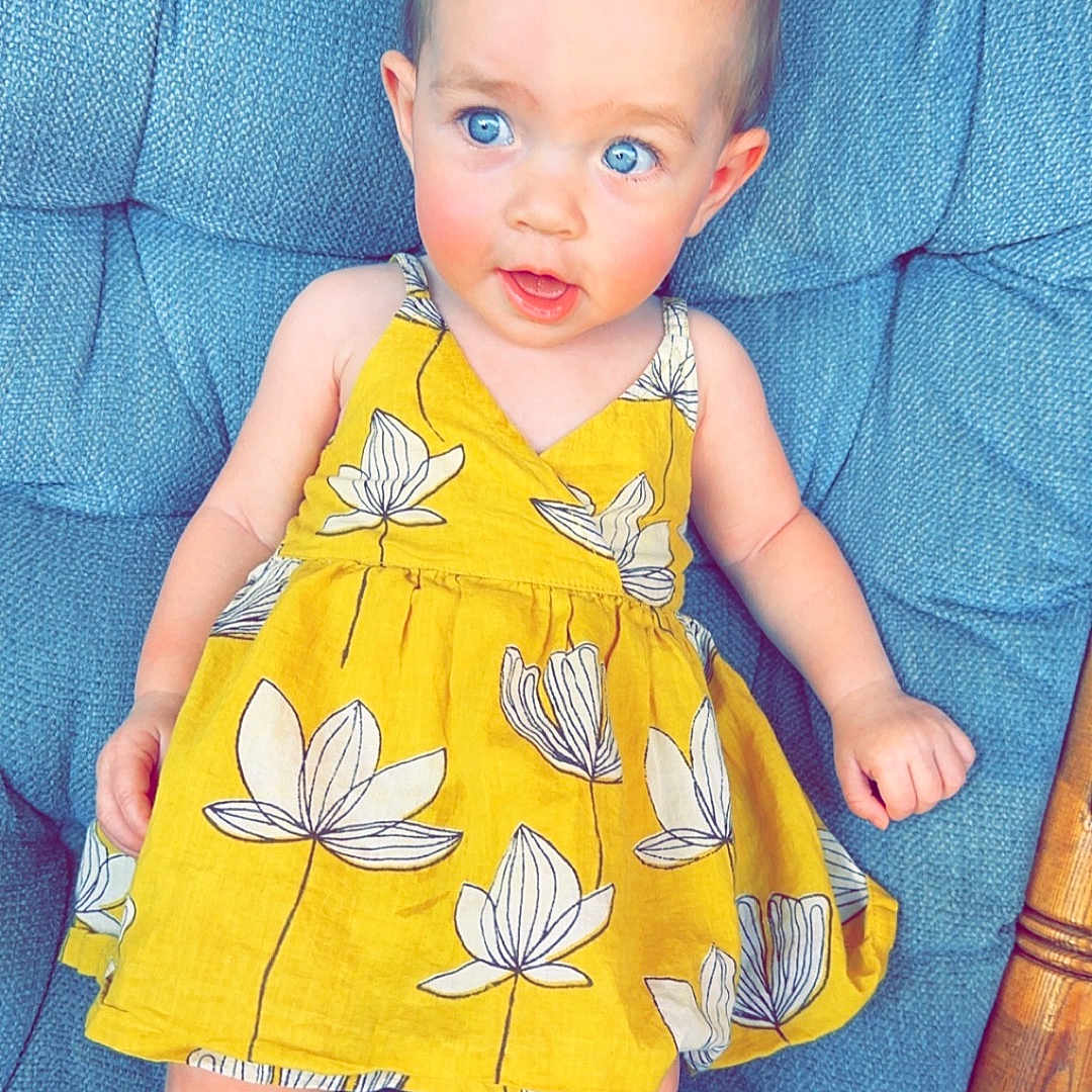 Ivy is registered to the contest to win money with this photo: baby, chair, clothing, costume, couch, cushion, dress, face, flower, formalwear, furniture, head, homedecor, linen, pants, person, photography, portrait, sitting, skirt