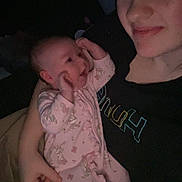 Melanie joined the competition — help win amazing prizes! baby, infant, woman, smile, face, person, clothing, onesie, holding, bedtime, indoor, dark, portrait, happy, parent, child, family, blanket, cozy, love