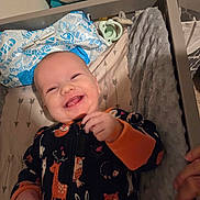 Makenzie is registered to the contest to win money with this photo: baby, infant, smiling, crib, onesie, animal_print, pacifier, diaper_package, blanket, bedding, adult_hand, cute, happy, nursery, pajamas, portrait, cheeks, tooth, woodland_animals, sleeping_area