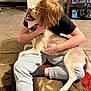Beau-Bella joined the competition — help win amazing prizes! black_shirt, carpet, collar, dog, floor, furniture, happy, home, hugging, husky, indoor, person, pet, photoframes, red_hair, shelf, sitting, smiling, sweatpants, warm_lighting