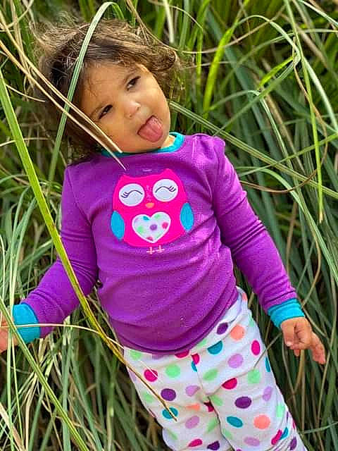 Nelli is registered to the contest to win money with this photo: baby_toddler_clothing, beauty, child, clothing, face, grass, grass_family, green, happy, magenta, outerwear, pattern, people_in_nature, person, pink, plant, purple, sleeve, t_shirt, toddler