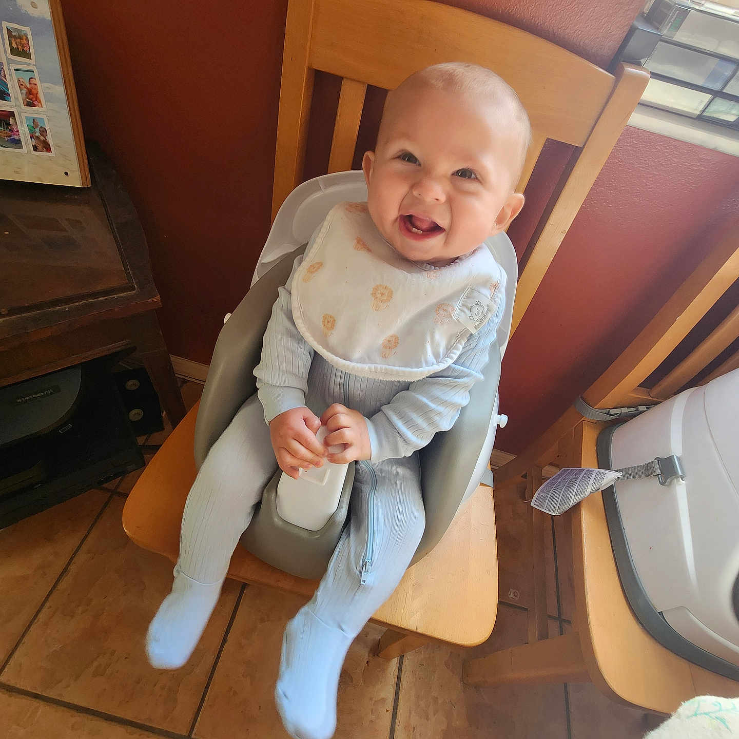 Richmond is registered to the contest to win money with this photo: baby, baby_clothing, baby_seat, bib, blue_outfit, child, dining_room, face, floor_tiles, hands, happy, high_chair, home, indoor, infant, person, smiling, table, window, wooden_chair