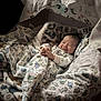Julius joined the competition — help win amazing prizes! baby, blanket, dinosaur_pattern, sleeping, smiling, infant, cozy, soft_lighting, cute, wrapped, bed, comfort, child, pajamas, home, resting, peaceful, young, portrait, indoors