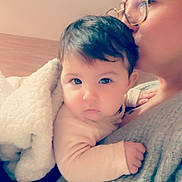 Sakura a rejoint le concours — aidez-le/la à gagner de superbes lots ! baby, adult, glasses, blanket, cuddle, indoor, affection, person, warm_clothing, head, face, hand, soft_texture, closeup, parent, love, tenderness, skin, portrait, cozy