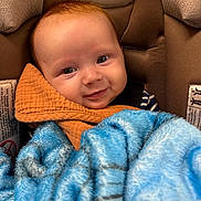 Maverick joined the competition — help win amazing prizes! baby, infant, car_seat, blanket, blue_blanket, orange_cloth, smiling, face, eyes, child, young, cute, cozy, warm, comfort, seat, fabric, closeup, portrait, indoor