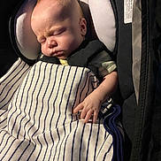 Wayden is registered to the contest to win money with this photo: baby, sleeping, blanket, striped, car_seat, infant, child, peaceful, cute, hand, face, clothing, soft_light, indoors, portrait, young_child, resting, cozy, newborn, toddler
