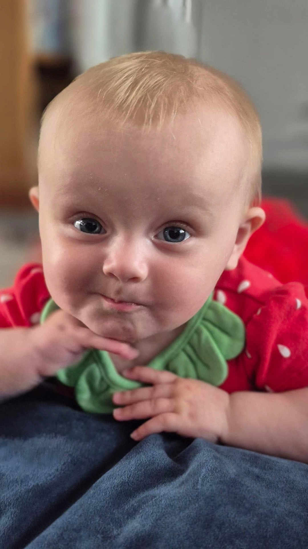 Skylar joined the competition — help win amazing prizes! baby, child, face, smile, hands, red_clothing, green_collar, blanket, blue_blanket, indoors, closeup, cute, infant, expression, portrait, skin, head, eyes, person, toddler