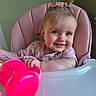 baby, child, smile, high_chair, pink, sippy_cup, hair_bows, two_ponytails, cute, indoor, person, face, infant, toddler, cheerful, pink_clothing, table, hand, closeup, happy