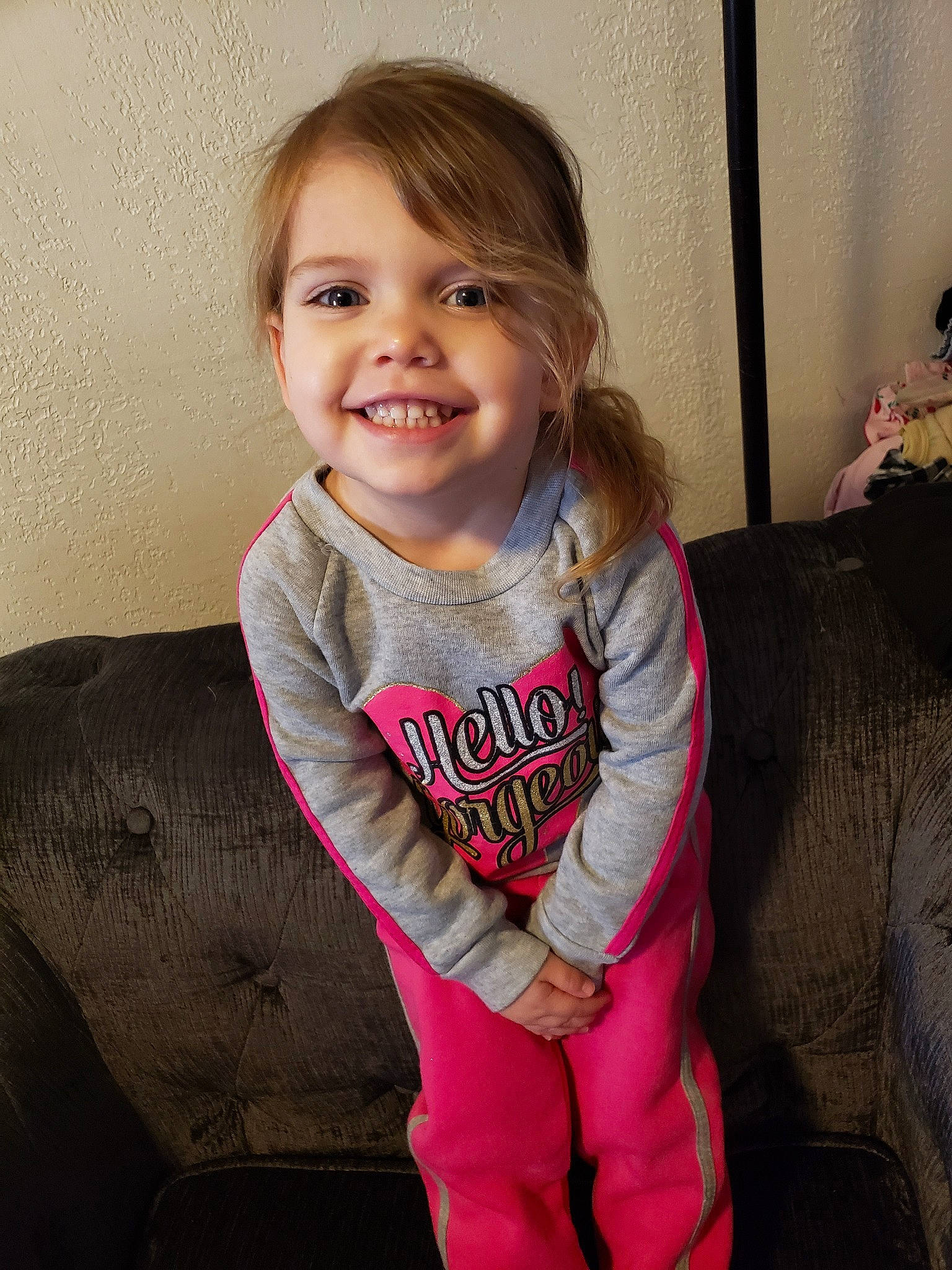 Hayven is registered to the contest to win money with this photo: baby_toddler_clothing, cheek, child, face, facial_expression, happy, joy, laugh, outerwear, person, pink, sitting, skin, sleeve, smile, standing, t_shirt, toddler, tooth