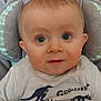 baby, blue_eyes, casual, child, closeup, clothing, curious, cushion, cute, dinosaur_shirt, expression, face, head, indoor, infant, person, portrait, seat, toddler, young_child