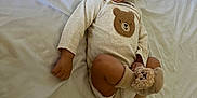 Máximo is registered to the contest to win money with this photo: baby, bear_patch, bear_socks, bed, blanket, child, cozy, cute, footwear, happy, indoors, infant, lying_down, onesie, playful, portrait, smiling, soft_toys, toddler, white_bed_sheets