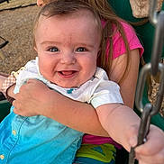 Sebastian joined the competition — help win amazing prizes! baby, child, swing, playground, smile, hug, blue_eyes, pink_shirt, green_shorts, outdoor, sunlight, happy, person, grass, fence, chain, holding, summer, cute, portrait