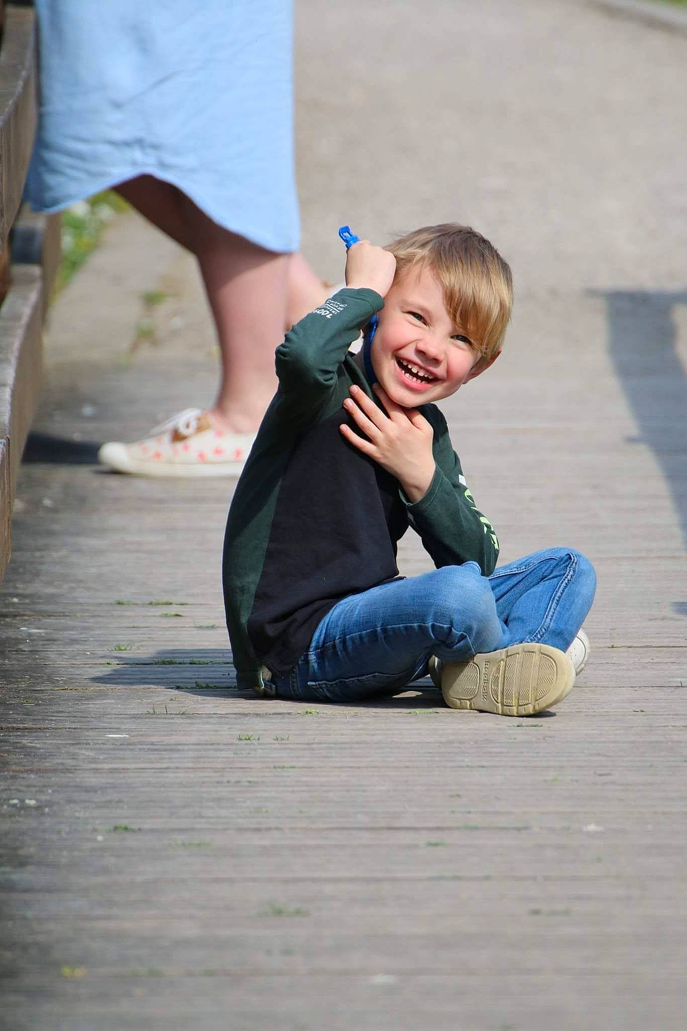 Raphael a rejoint le concours — aidez-le/la à gagner de superbes lots ! child, denim, flooring, foot, fun, gesture, grass, happy, human_leg, joint, joy, leg, leisure, mammal, people_in_nature, person, recreation, sitting, smile, sneakers