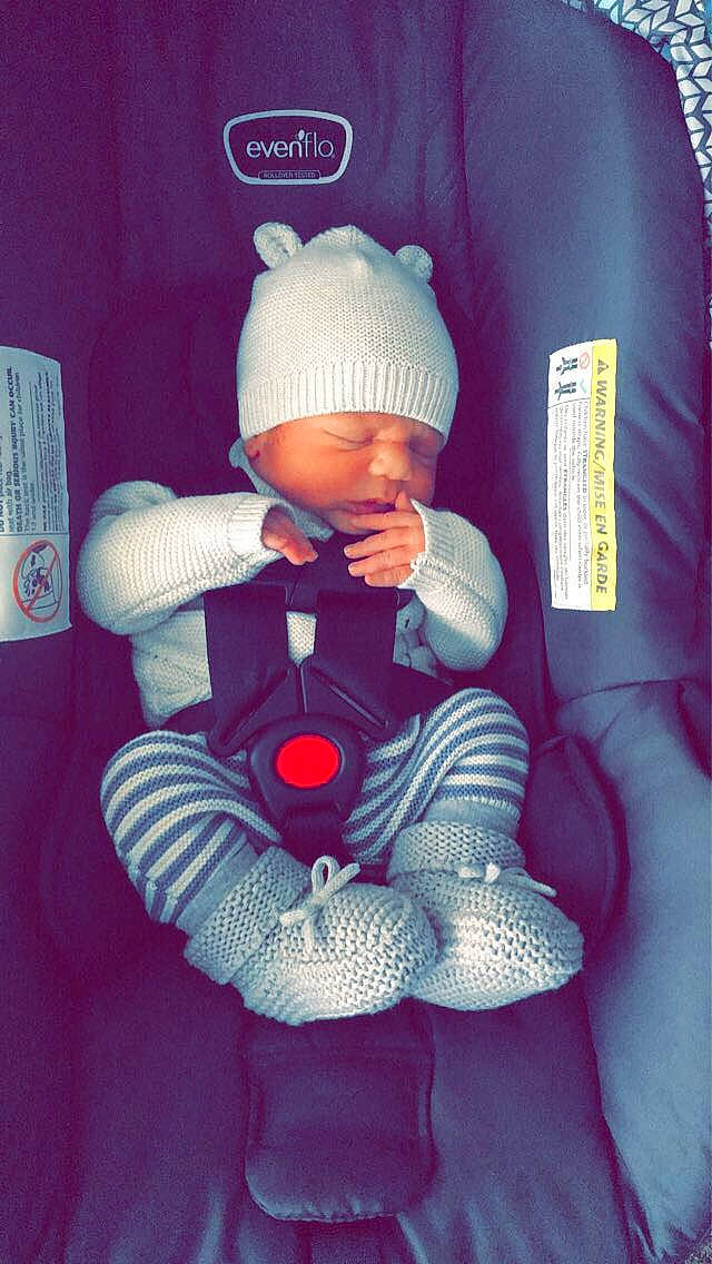 Xavier is registered to the contest to win money with this photo: art, baby, baby_toddler_clothing, beanie, cap, car_seat, carmine, comfort, electric_blue, fictional_character, headwear, knit_cap, lap, magenta, person, purple, sitting, sleeve, textile, thumb