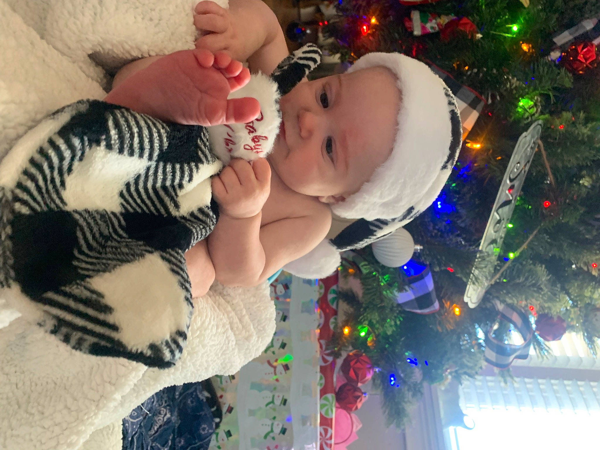 Justin is registered to the contest to win money with this photo: baby, baby_toddler_clothing, beauty, christmas_decoration, christmas_ornament, christmas_tree, facial_expression, fun, green, happy, head, holiday_ornament, human_body, light, people, person, photograph, plant, toddler, tree