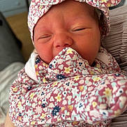 Ellie joined the competition — help win amazing prizes! newborn, baby, infant, face, headband, floral_pattern, clothing, sleeping, close_up, person, skin, hand, soft_light, indoors, cute, portrait, babywear, fabric, toddler, wrapped