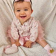 Agathe participe au concours pour gagner de l'argent avec cette photo : baby, child, smiling, pink, headband, flower, tutu, sitting, blanket, soft, cute, happy, portrait, indoors, sock, toddler, clothing, face, hands, feet