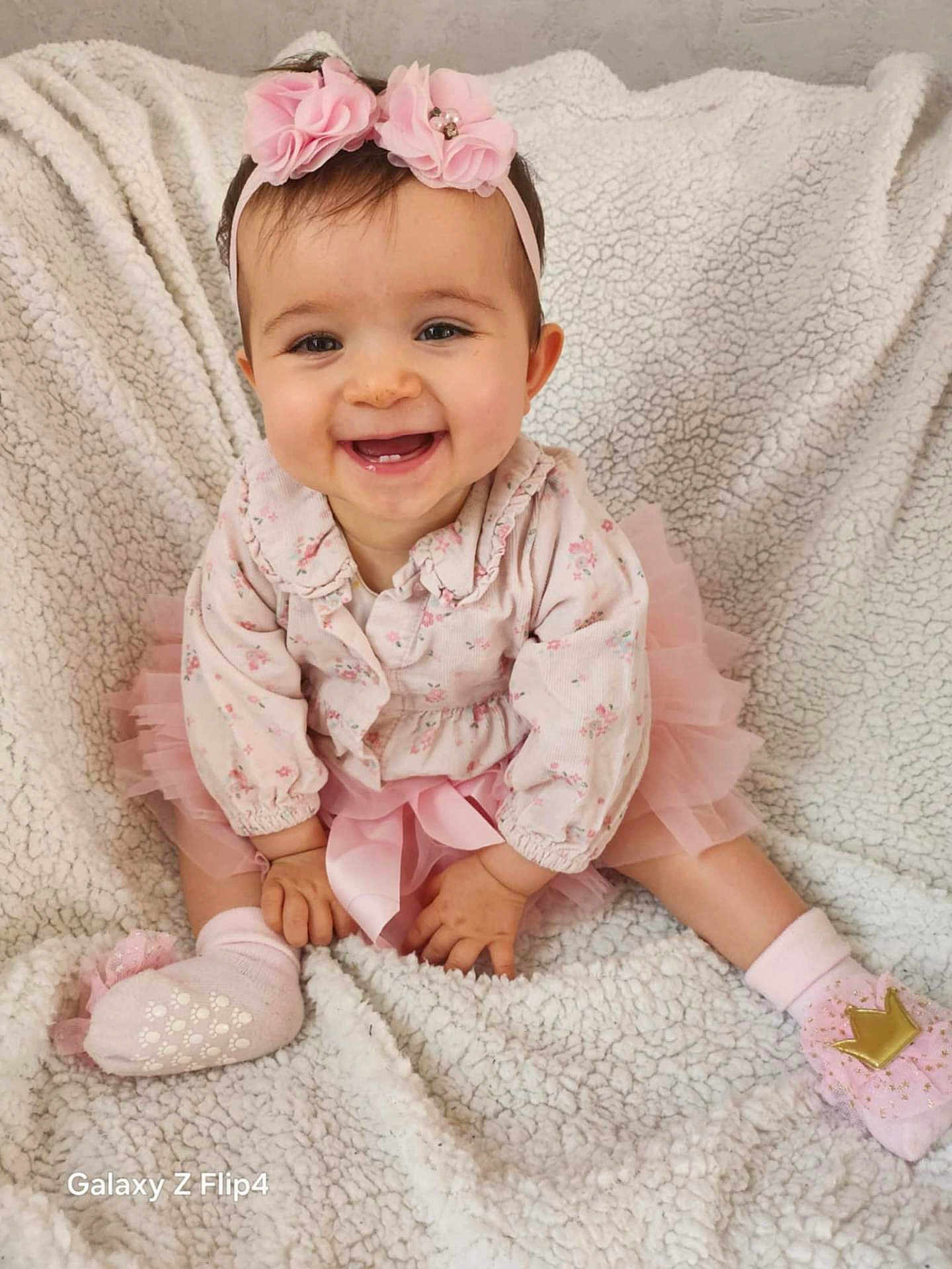 Agathe participe au concours pour gagner de l'argent avec cette photo : baby, child, smiling, pink, headband, flower, tutu, sitting, blanket, soft, cute, happy, portrait, indoors, sock, toddler, clothing, face, hands, feet