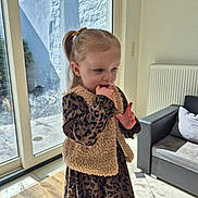 Elyne a rejoint le concours — aidez-le/la à gagner de superbes lots ! casual_clothing, child, couch, curious, daylight, dress, girl, hair_tie, home, indoor, leopard_print, pillow, portrait, radiator, sofa, standing, sunlight, vest, window, wooden_floor