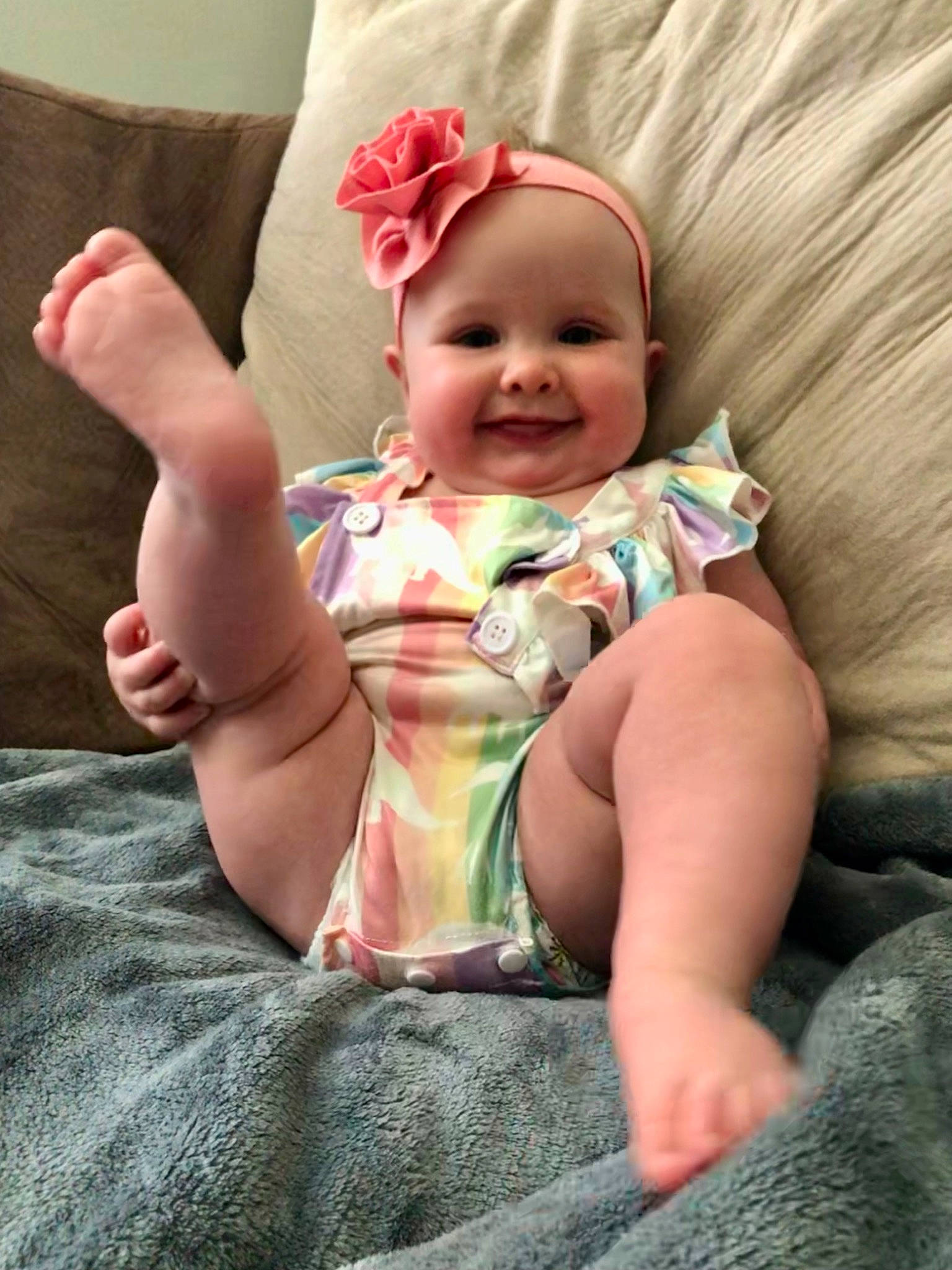 Aila is registered to the contest to win money with this photo: baby, baby_toddler_clothing, child, comfort, eye, face, finger, foot, gesture, hand, happy, head, headgear, headwear, human_leg, joy, leg, person, pink, skin