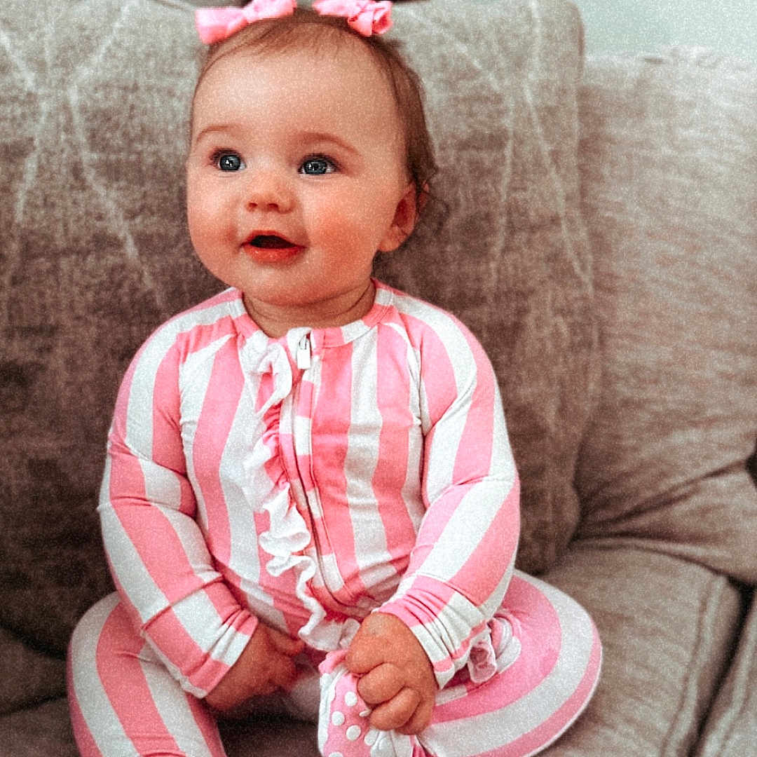 Mylah is registered to the contest to win money with this photo: accessories, architecture, baby, building, clothing, couch, cushion, face, furniture, happy, head, homedecor, indoors, livingroom, pajamas, pants, person, photography, portrait, sitting