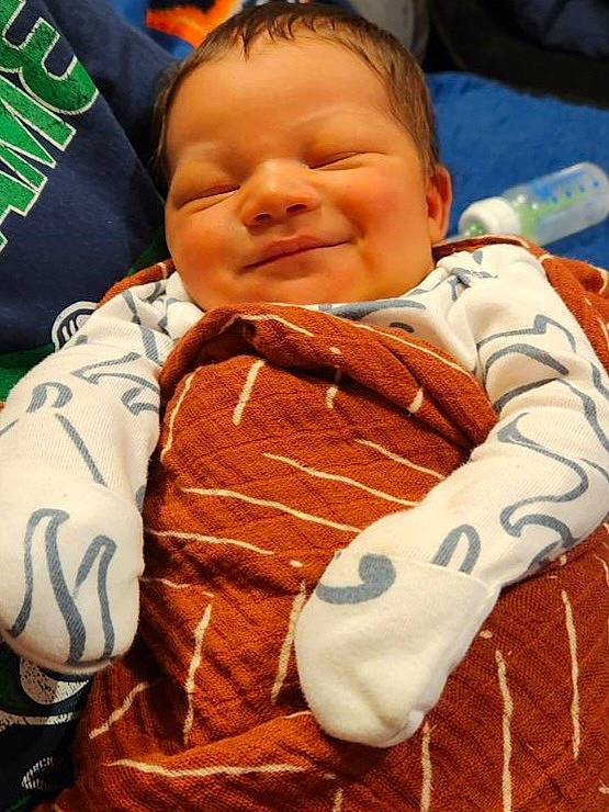 Cairo joined the competition — help win amazing prizes! baby, baby_products, baby_toddler_clothing, bib, cheek, child, chin, comfort, fun, happy, joy, linens, orange, pattern, person, sitting, skin, sleeve, smile, textile