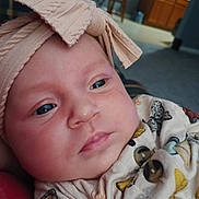 Arielle is registered to the contest to win money with this photo: baby, infant, headband, bow, face, closeup, clothing, pattern, butterfly, buttons, indoor, carpet, furniture, person, cute, child, newborn, soft, portrait, skin