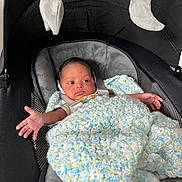 Jackson is registered to the contest to win money with this photo: baby, infant, car_seat, blanket, crocheted_blanket, plush_toy, moon_toy, star_toy, child, seatbelt, soft_toys, indoor, newborn, cute, wrapped, resting, small_hands, cozy, portrait, expression