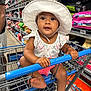 aisle, baby, child, clothing, colorful, curious, cute, face, foot, hand, hat, infant, person, pet_food, retail, shopping, shopping_cart, sitting, store, wide_eyes