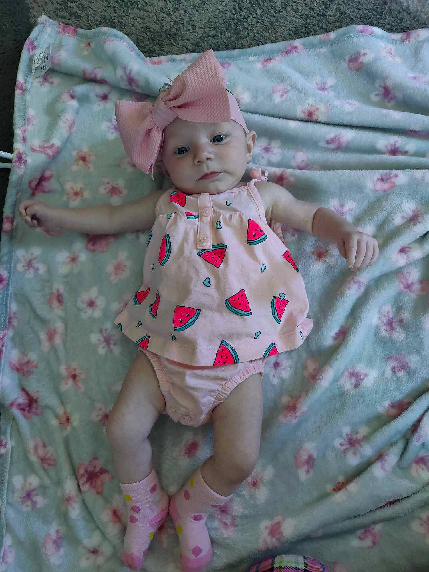 Nevaeh Kidd is registered to the contest to win money with this photo: baby, baby_products, baby_toddler_clothing, child, day_dress, doll, dress, eye, grass, headwear, linens, magenta, one_piece_garment, pattern, person, pink, sitting, sleeve, sun_hat, textile